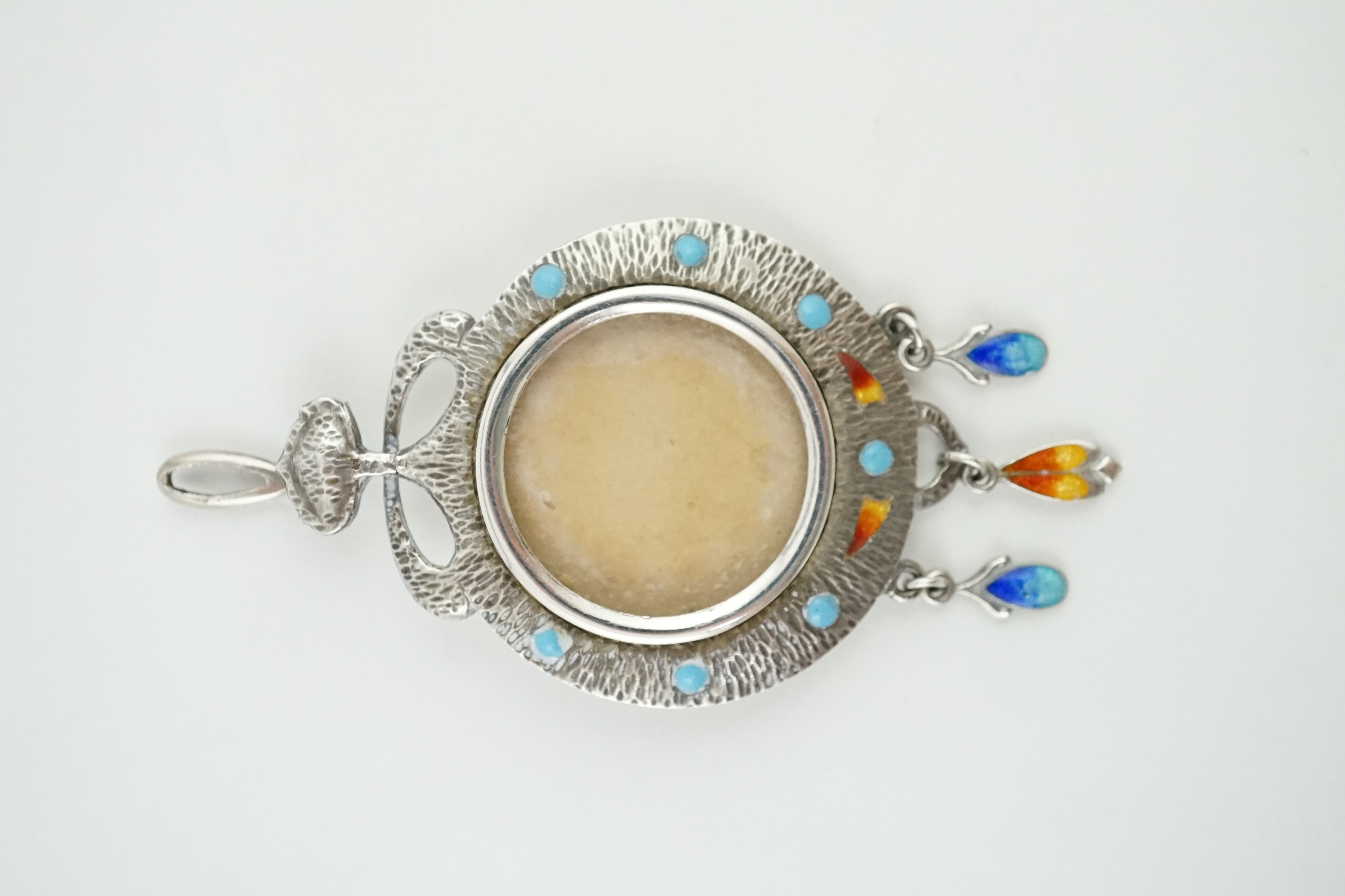 An Edwardian Art Nouveau silver, enamelled and turquoise inset bark textured silver portrait pendant, Abrahall & Bint, Birmingham, 1906, 58mm. Condition - poor to fair